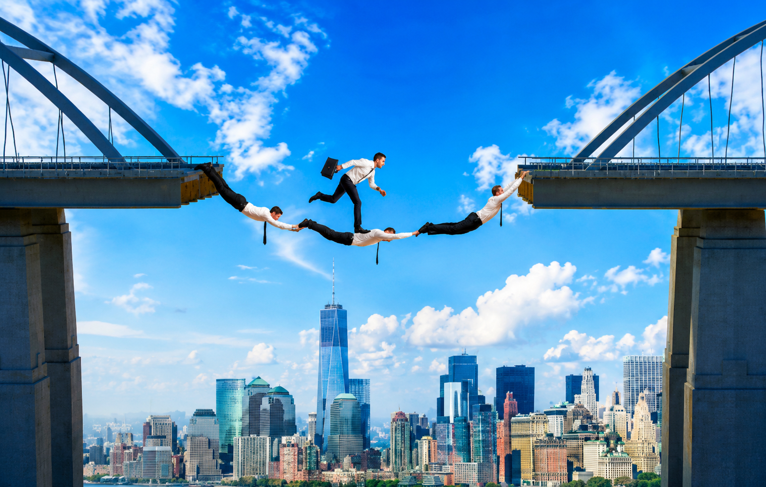 Business professionals bridging the gap above a city skyline